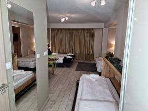Habitación de hotel con 2 camas y sala de estar. en AGAT Apartament Czarna Góra en Sienna