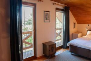 ein Schlafzimmer mit einem Bett und zwei großen Fenstern in der Unterkunft Cottage in Domaša. Chata na Domaši. in Bžany