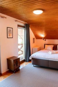 ein Schlafzimmer mit einem Bett und einem großen Fenster in der Unterkunft Cottage in Domaša. Chata na Domaši. in Bžany