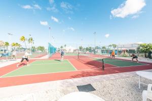 a group of people playing tennis on a tennis court at NAUTILUS...ocean front cottage retreat ~ in Cudjoe Key