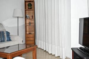 a living room with a couch and a window with curtains at Apartamento LLac,bahía de Alcudia. in Alcudia
