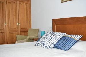 a bed with a pillow and a chair in a room at Apartamento LLac,bahía de Alcudia. in Alcudia
