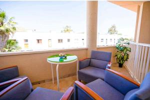 balcón con sillas, mesa y ventana en Apartamento LLac,bahía de Alcudia., en Alcudia