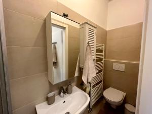 a bathroom with a sink and a toilet and a mirror at Cozy 2-room apartment in Vienna