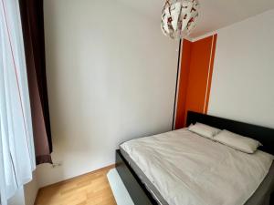 um pequeno quarto com uma cama e um lustre em Cozy 2-room apartment em Viena