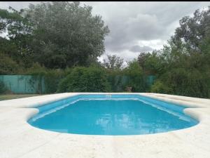 a swimming pool with blue water in a yard at El puesto in Lobos