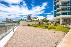 una pasarela frente a un edificio con mesas y sombrillas en Condo Gorgona Beach Apartamento de Lujo de 2 Habitaciones, en Chame