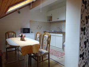 a kitchen with a table and chairs and a kitchen with a counter at Era Apartman in Harkány