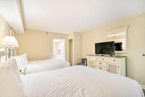 a bedroom with two beds and a flat screen tv at Oceanfront Myrtle Beach Condo with Balcony! in Myrtle Beach