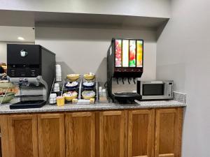 a kitchen with a counter with a microwave and some cupcakes at Reston Inn & Suites in Spencer