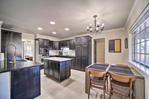 a kitchen with black cabinets and a table and chairs at Immaculate Woodland View Retreat with Hot Tub in Tulsa