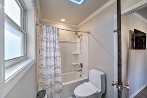 a bathroom with a toilet and a shower curtain at Immaculate Woodland View Retreat with Hot Tub in Tulsa +27 photos