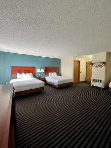 two beds in a hotel room with two beds sidx sidx sidx at Reston Inn & Suites in Spencer