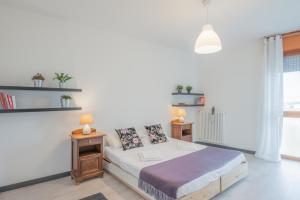 een witte kamer met een bed en twee tafels bij Cappella degli Scrovegni Grey Apartment in Padua
