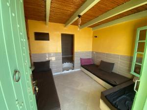 Habitación con sofá en una habitación con paredes amarillas en WEST COAST HOSTEL en Imsouane