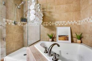 a bathroom with a bath tub and a sink at The Owl's Nest @ Manitou: Mtn Views on Main Street in Manitou Springs