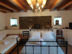sypialnia z 2 łóżkami i zegarem na ścianie w obiekcie Xenia's Traditional House w mieście Andros