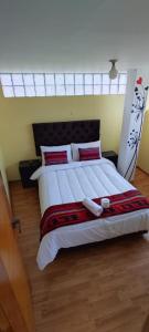 ein Schlafzimmer mit einem großen weißen Bett mit roten Kissen in der Unterkunft cusco pasay in Cusco