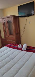 a bedroom with two beds and a tv on the wall at cusco pasay in Cusco