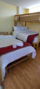 2 Etagenbetten in einem Zimmer mit Holzböden in der Unterkunft cusco pasay in Cusco