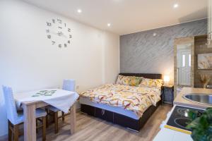 a bedroom with a bed and a table and a sink at Apartments Solar Trebinje in Trebinje