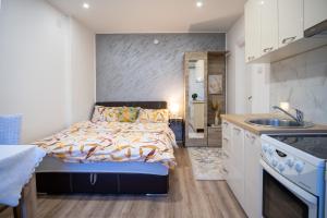 a small bedroom with a bed and a kitchen at Apartments Solar Trebinje in Trebinje