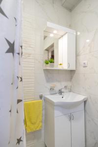 a white bathroom with a sink and a mirror at Apartments Solar Trebinje in Trebinje