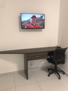 une télévision installée au-dessus d'un bureau en bois dans l'établissement Liso’s Place Guest House, à Pretoria