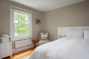 a bedroom with a white bed and a window at Lakehouse Inn in Lee