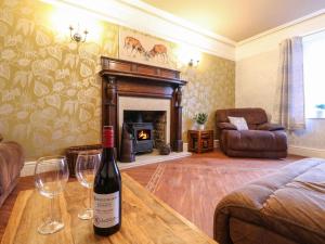 a living room with a bottle of wine and glasses on a table at The Old Post Office in Matlock