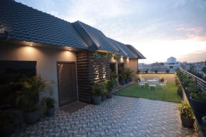 a house with a patio with tables and chairs at OVEL HOTEL (LUXURY) in Ludhiana