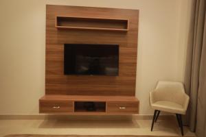 a living room with a tv and a chair at OVEL HOTEL (LUXURY) in Ludhiana