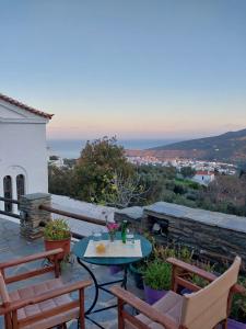 a patio with two chairs and a table with a view at Xenia's Traditional House in Andros