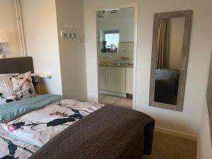 a small bedroom with a bed and a mirror at Apartment Ella with free privat parking in Zandvoort