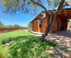 una pequeña casa con un árbol en el patio en Ikigai en Los Molles