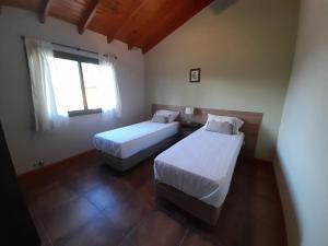 1 dormitorio con 2 camas y ventana en Ikigai en Los Molles