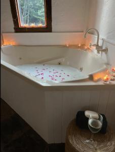 Daylesford FROG HOLLOW ESTATE- The Retreat في ديلسفورد: حوض استحمام أبيض مع الشموع ونافذة