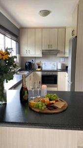 a kitchen with a plate of fruit and wine glasses at The Palms 3 bedroom loft apartment in leafy suburb in Durban