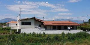 une maison avec un toit rouge sur un champ dans l'établissement Villa Mira, à Rizómilos