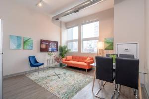 a living room with an orange couch and chairs at McCormick Place 2br-2ba with Optional Parking, Patio, Gym access for 6 guests in Chicago