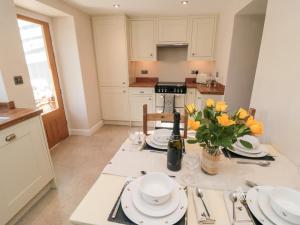 a kitchen with a table with plates and flowers on it at Appletree Cottage in Scarborough