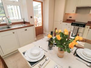 eine Küche mit einem Tisch, auf dem gelbe Blumen stehen in der Unterkunft Appletree Cottage in Scarborough + 13 Fotos