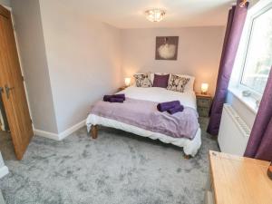 a bedroom with a bed and a window at Appletree Cottage in Scarborough