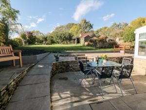 eine Terrasse mit einem Tisch, Stühlen und einer Bank in der Unterkunft Appletree Cottage in Scarborough