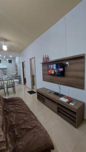 sala de estar con TV de pantalla plana en la pared en FLAT ATITUDE " Maragogi CENTRO", en Maragogi