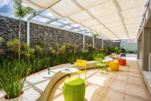 a patio with chairs and tables and a brick wall at THE EXPRESSION BUENO in Goiânia