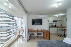 a bedroom with a table and chairs and a kitchen at THE EXPRESSION BUENO in Goiânia