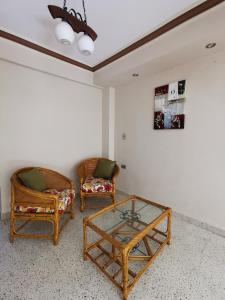 sala de estar con 2 sillas y mesa de centro en departamento céntrico y confortable, en Tarija