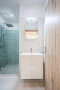 biała łazienka z umywalką i prysznicem w obiekcie Architecture Fan's Apartment near Opera House w Budapeszcie