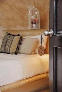 una porta con una chiave su un letto con gabbia per uccelli di Boutique Hotel Posada 06 Tulum a Tulum